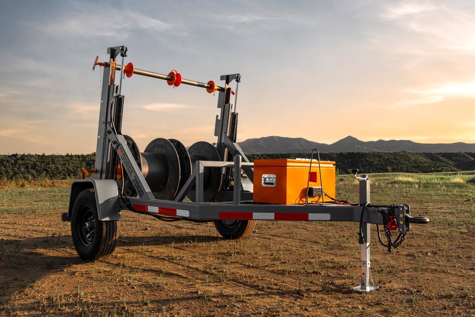 Side profile of a hydraulic cable reel trailer loaded with wire reels