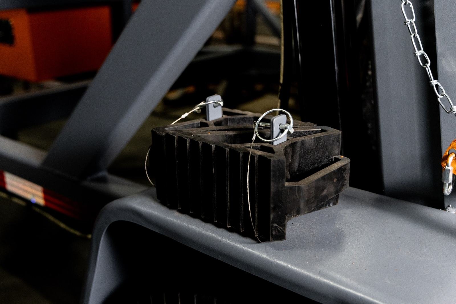 Wheel chock in its fender-mounted holder on a cable reel trailer